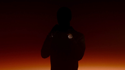 a person standing in the dark with their back to the camera