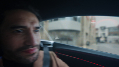 a man driving a car on a city street