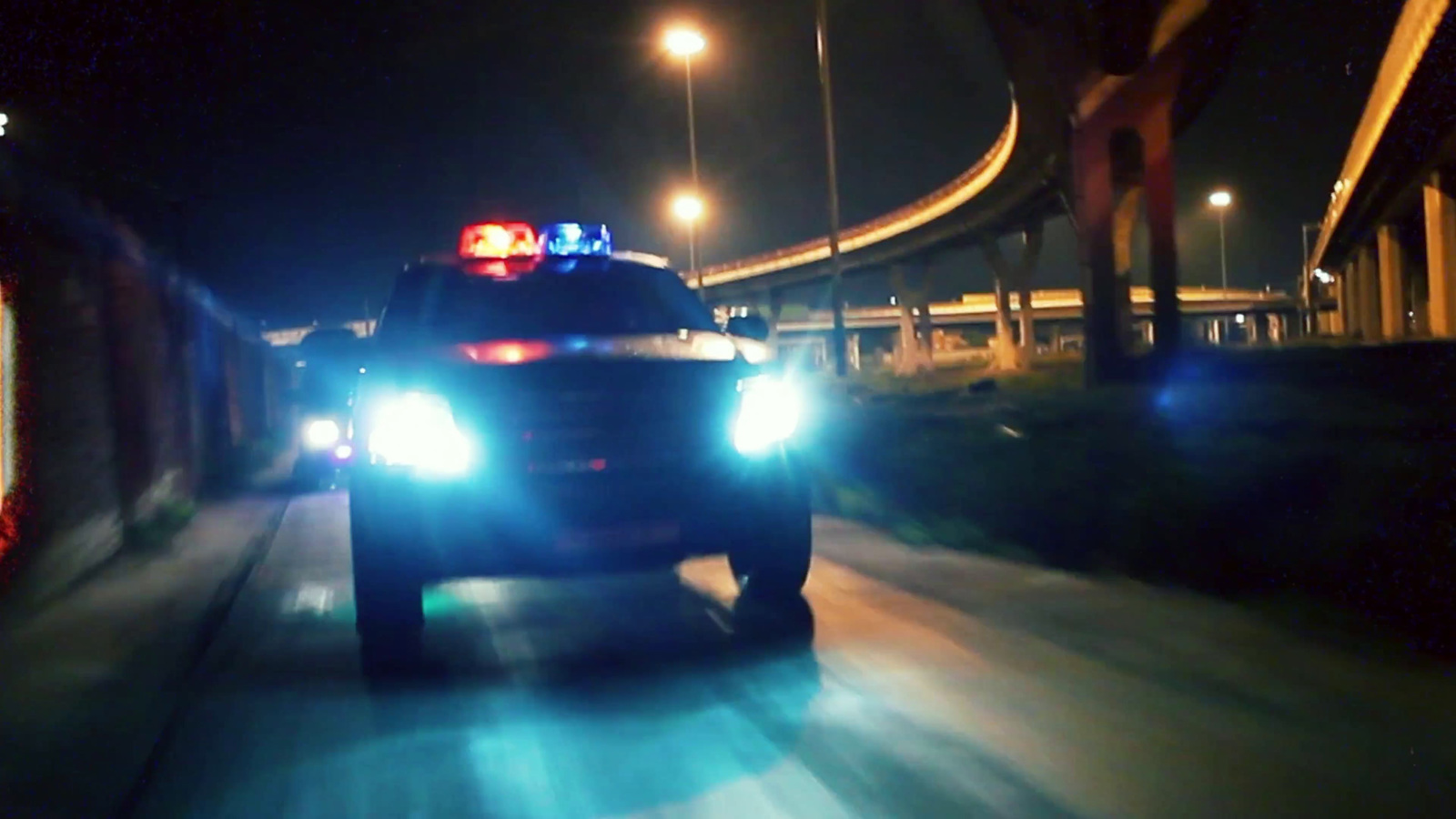 a police car driving down a street at night