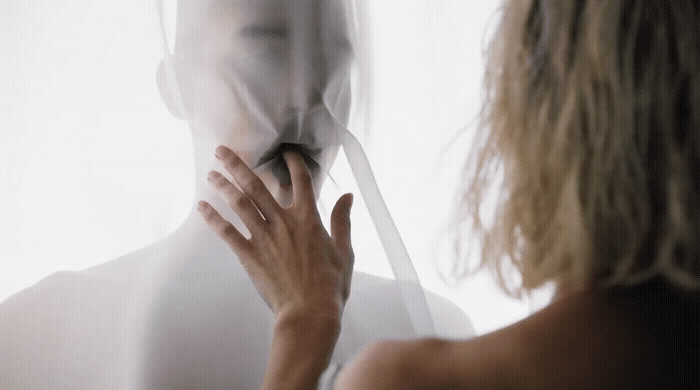 a woman standing in front of a mirror brushing her teeth