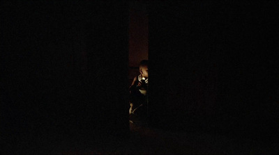 a person standing in the dark with a cell phone