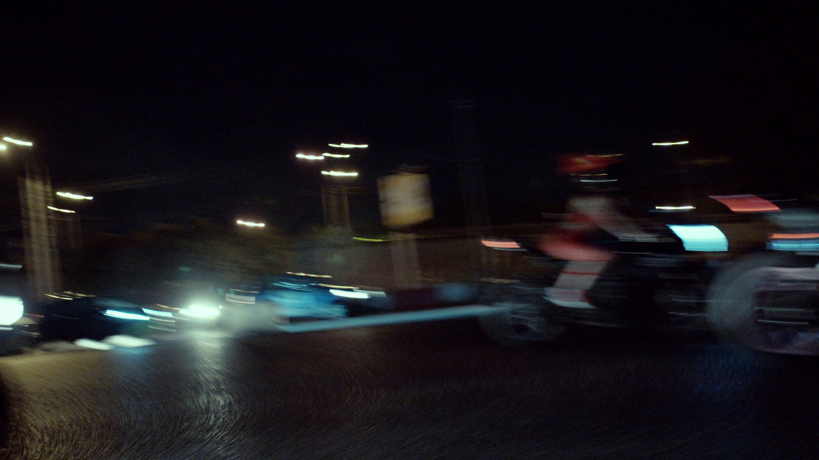 a blurry photo of a person riding a motorcycle at night