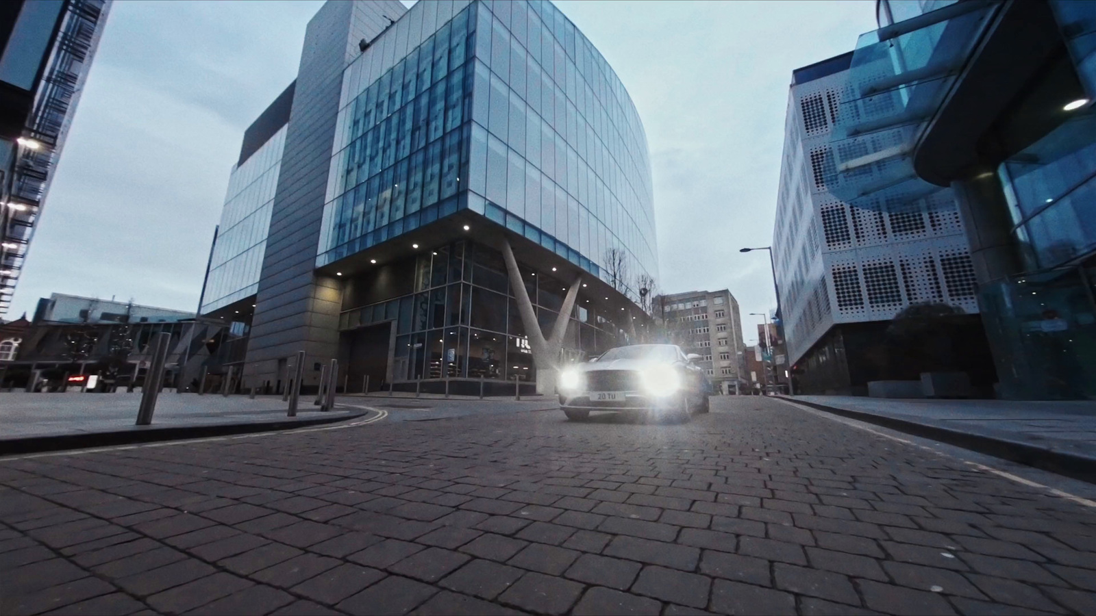 a car driving down a street next to tall buildings