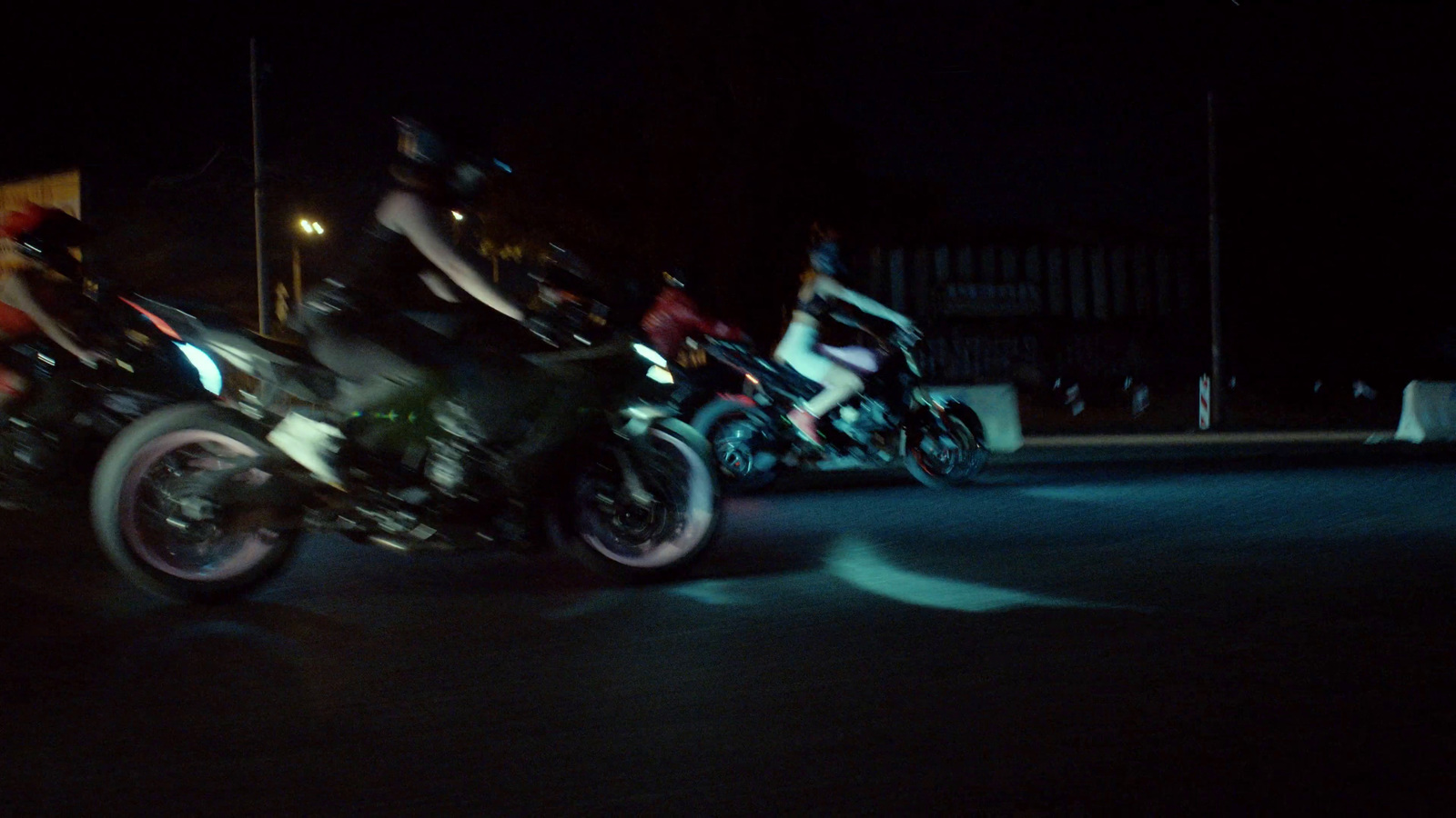 a group of people riding motorcycles at night