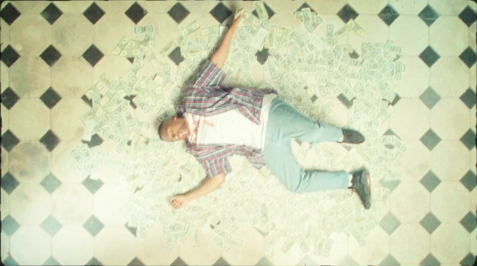 a man laying on a tiled floor with his arms in the air