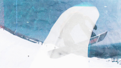 a man riding a snowboard down the side of a snow covered slope