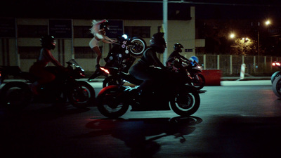 a group of people riding motorcycles at night