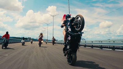 a group of people riding motorcycles down a road