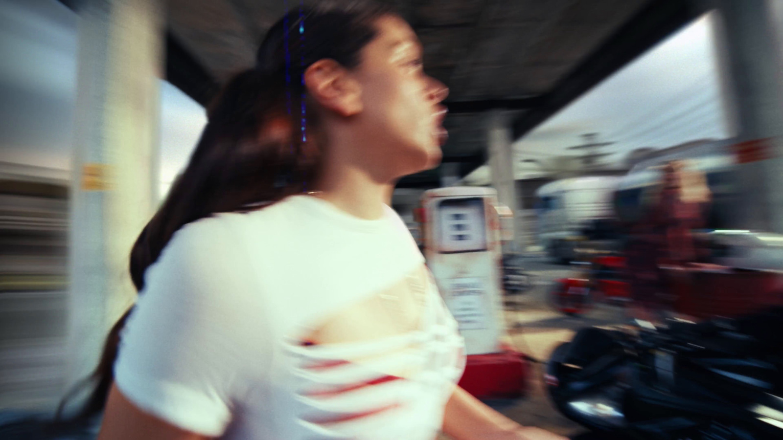 a woman in a white shirt standing next to a motorcycle