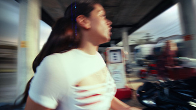 a woman in a white shirt standing next to a motorcycle