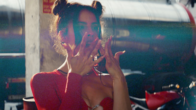 a woman in a red dress holding her hands up to her face