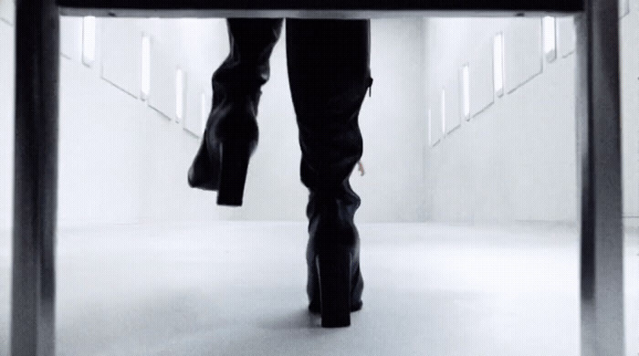 a woman in high heels walking down a hallway