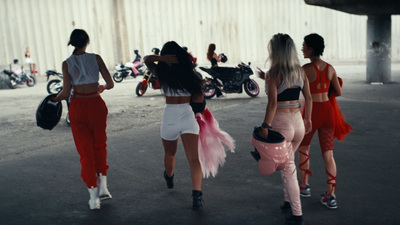 a group of women walking down a street next to motorcycles