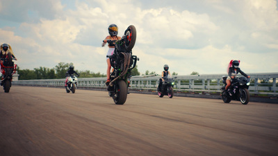 a group of people riding motorcycles down a road