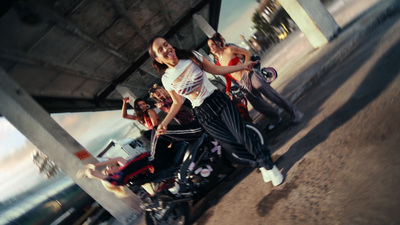 a woman riding a motorcycle next to a group of people