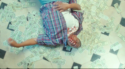 a young boy laying on top of a pile of money