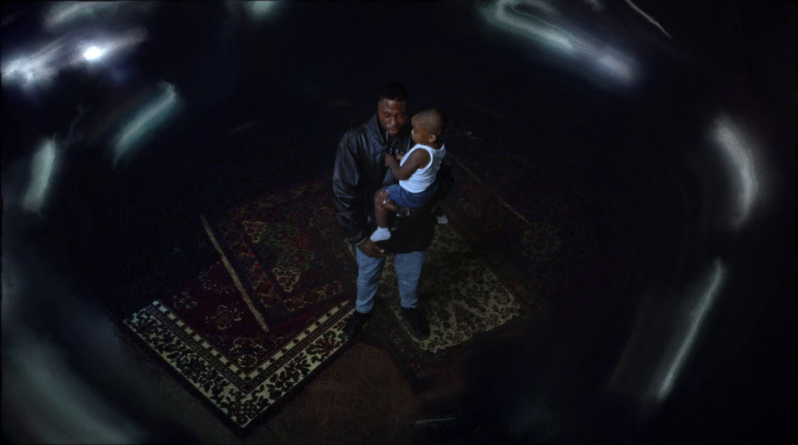 a man holding a child in a dark room