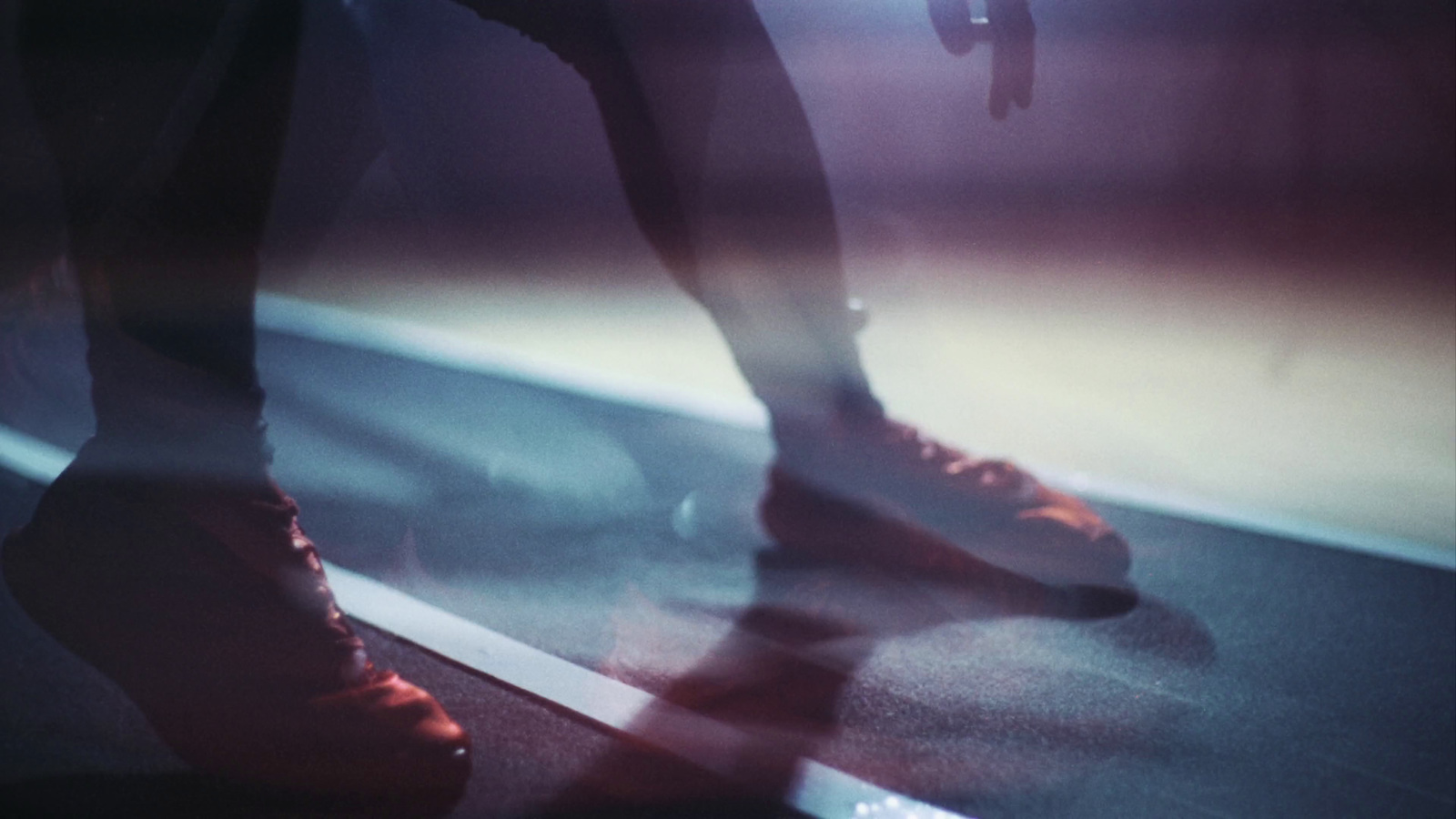 a person standing on a skateboard in the dark