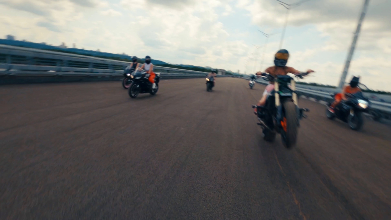 a group of people riding motorcycles down a road