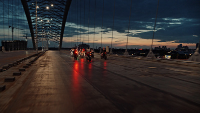 a group of people riding motorcycles on a bridge