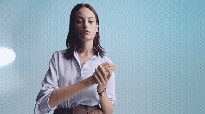 a woman in a white shirt and brown pants