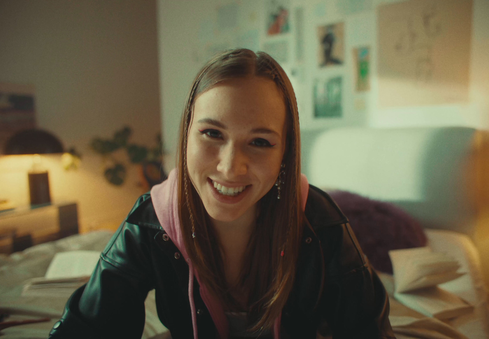 a woman sitting on a bed smiling at the camera