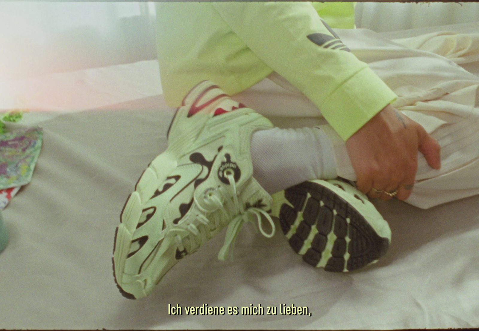 a person sitting on a bed with a pair of shoes