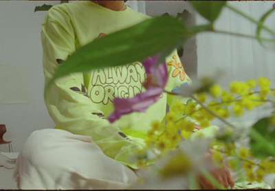 a woman in a yellow shirt sitting on a bed