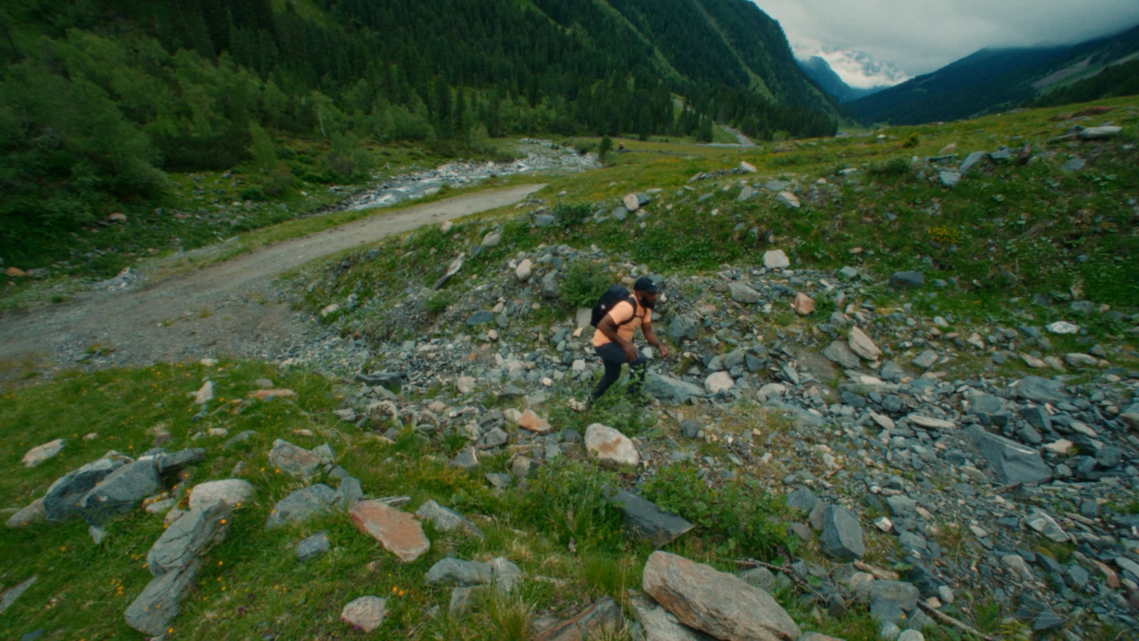 a man is hiking up a rocky hill