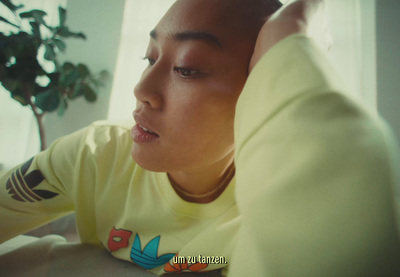 a man in a yellow shirt leaning on a table