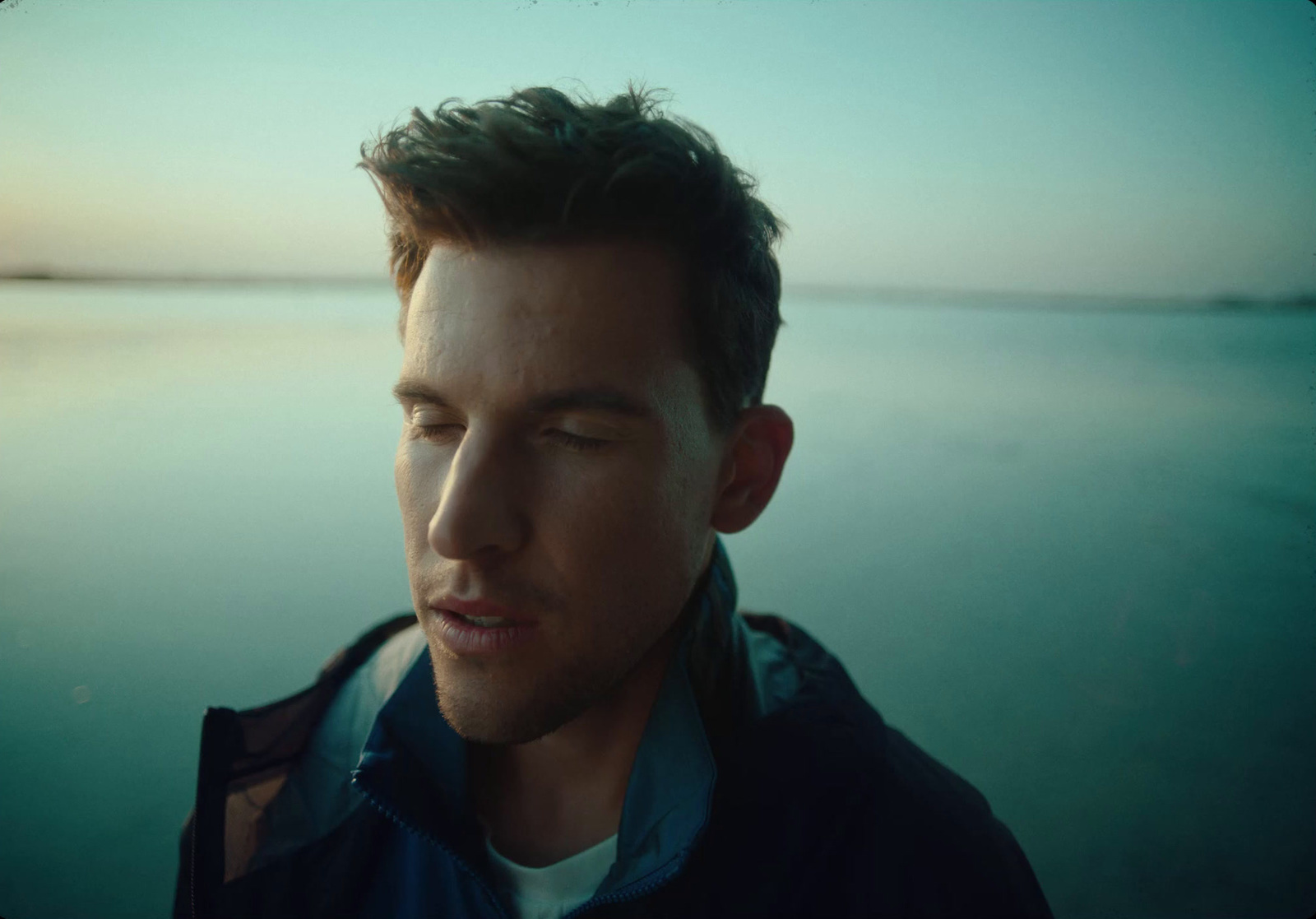 a man standing in front of a body of water