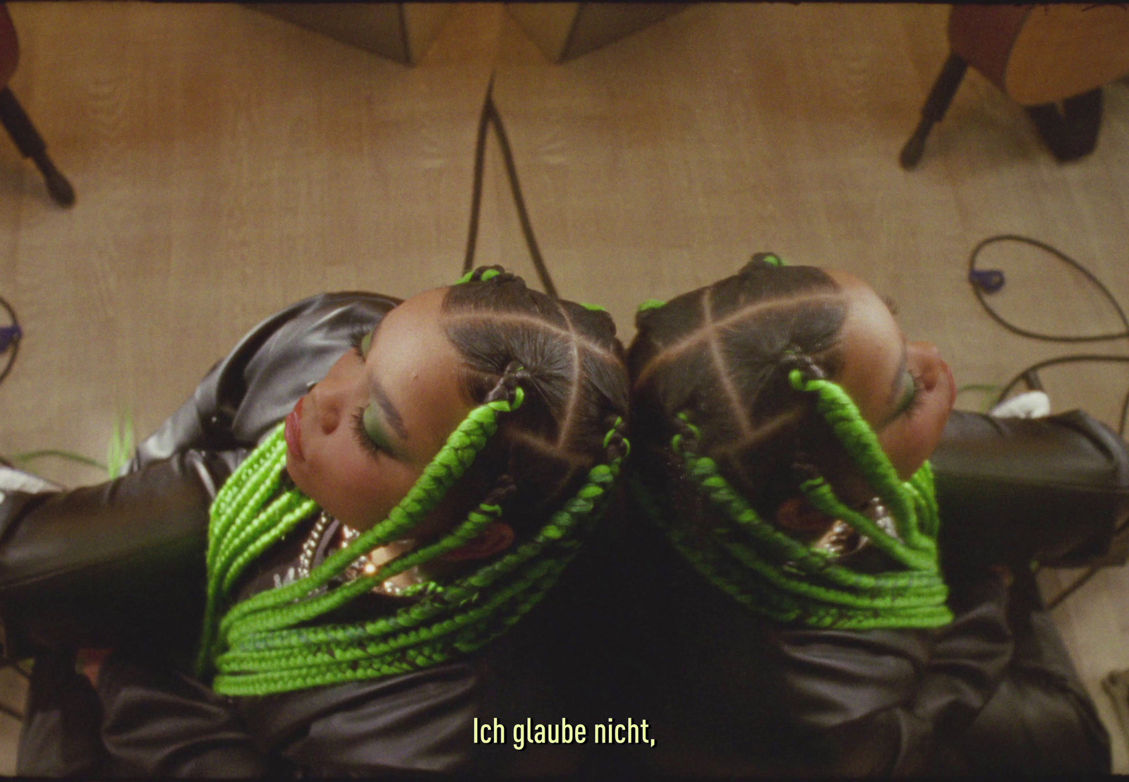 a woman with green braids laying on top of a couch