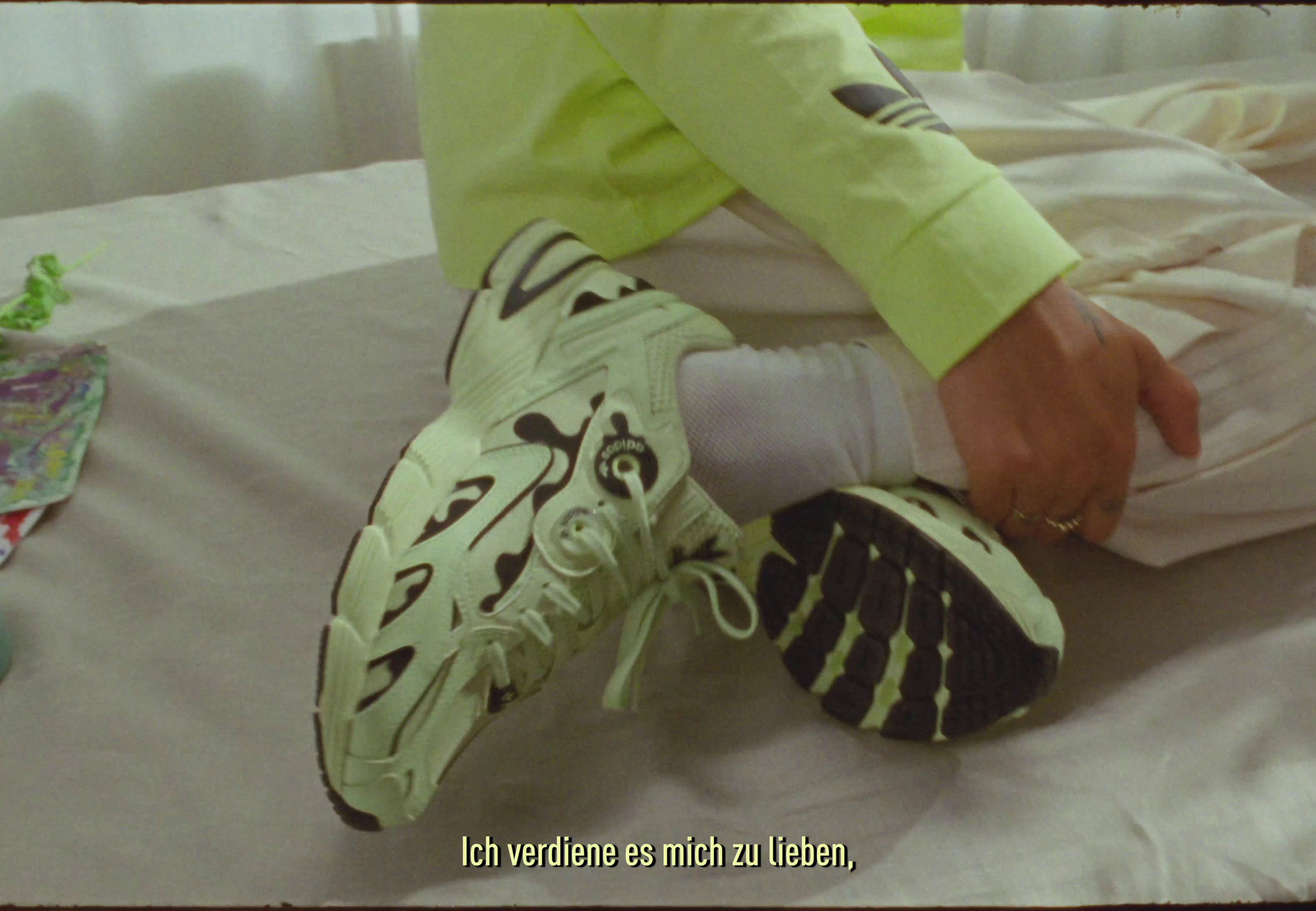 a person sitting on a bed with a pair of shoes