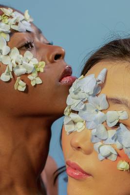 two women with flowers painted on their faces