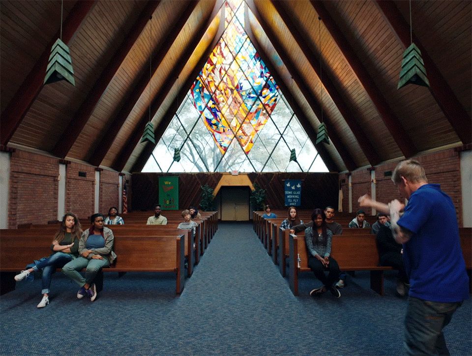 a group of people sitting in front of a stained glass window