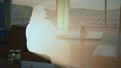 a person sitting at a table in front of a window