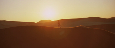 a person standing on top of a sand dune