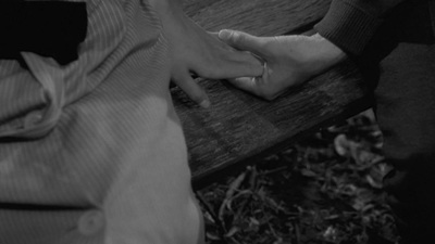 two people sitting on a bench holding hands