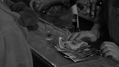 a man sitting at a bar with a glass of wine