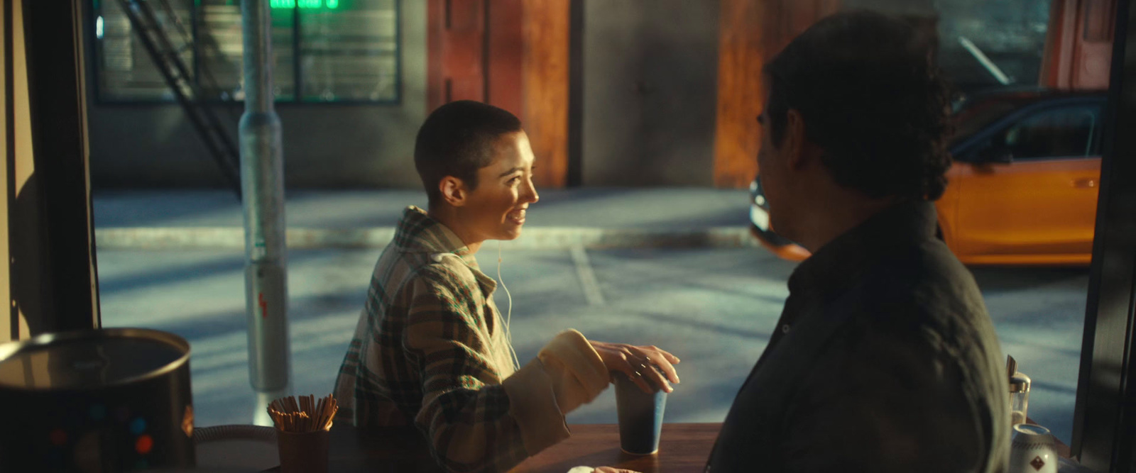 a man sitting at a table talking to another man