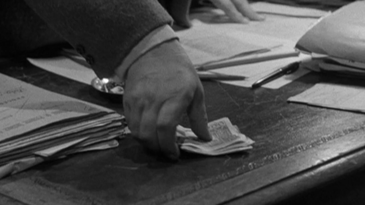 a person's hand on top of a pile of papers