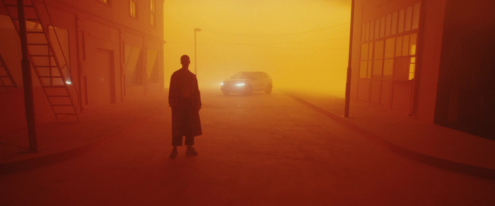 a man standing in a foggy street next to a car