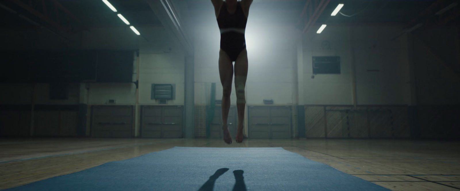 a person standing on a mat in a gym