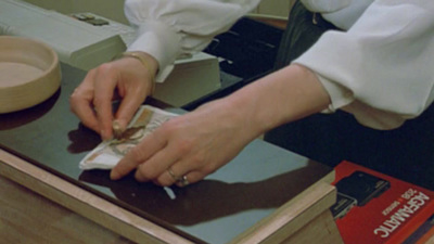 a woman in a white shirt is cutting a piece of paper