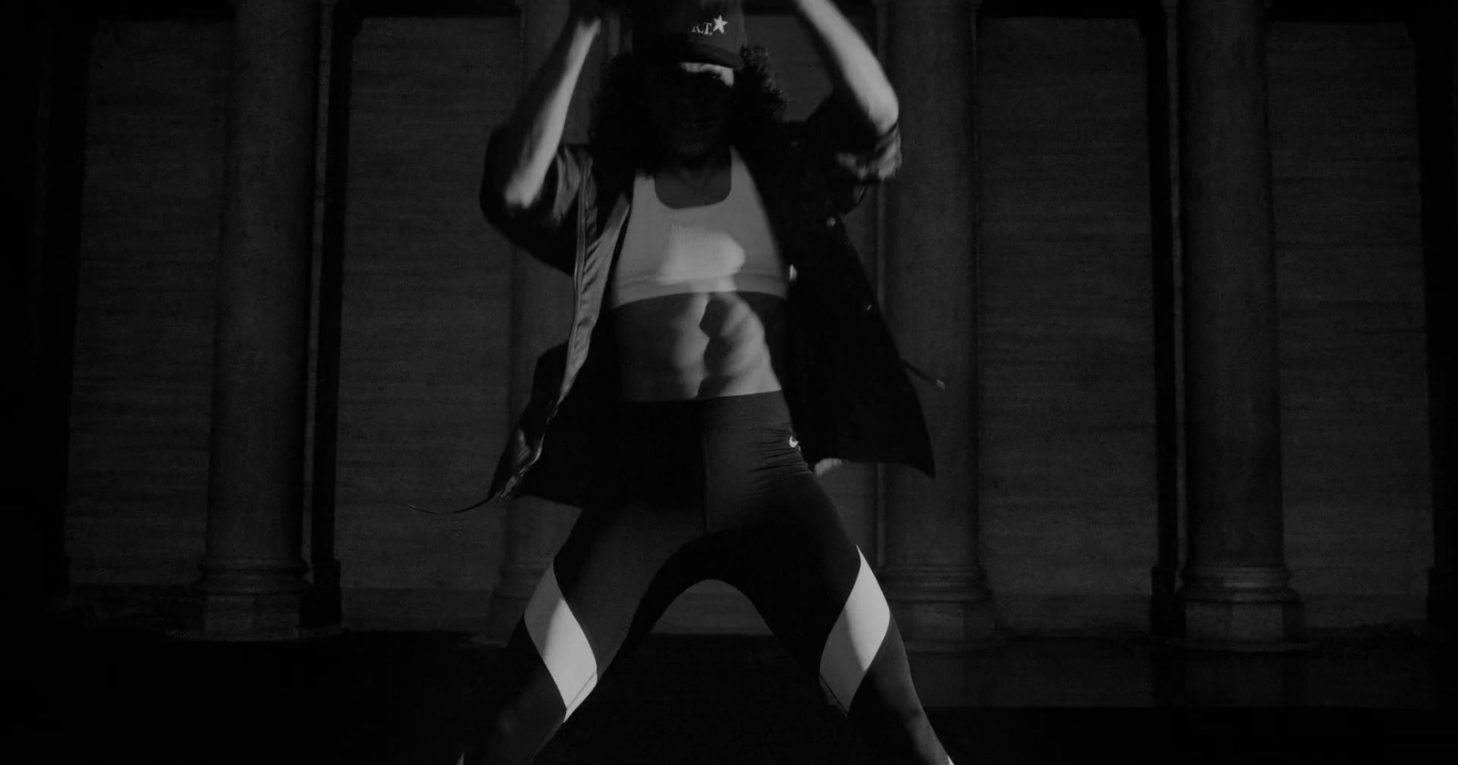 a woman standing in front of a building with her hands on her head