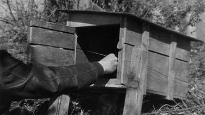 a black and white photo of a person opening a wooden box