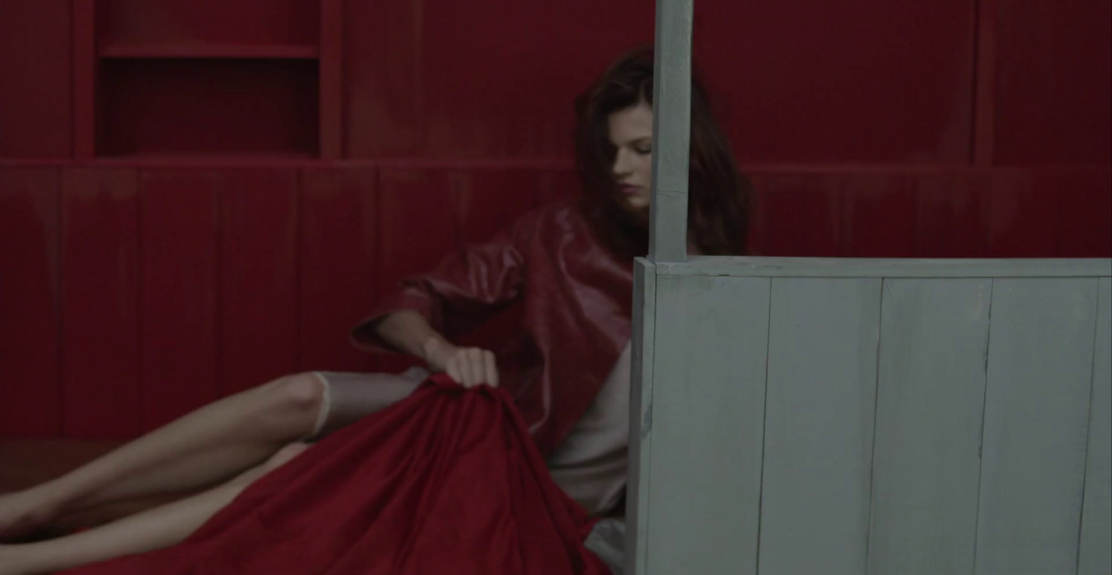 a woman in a red dress sitting on the floor