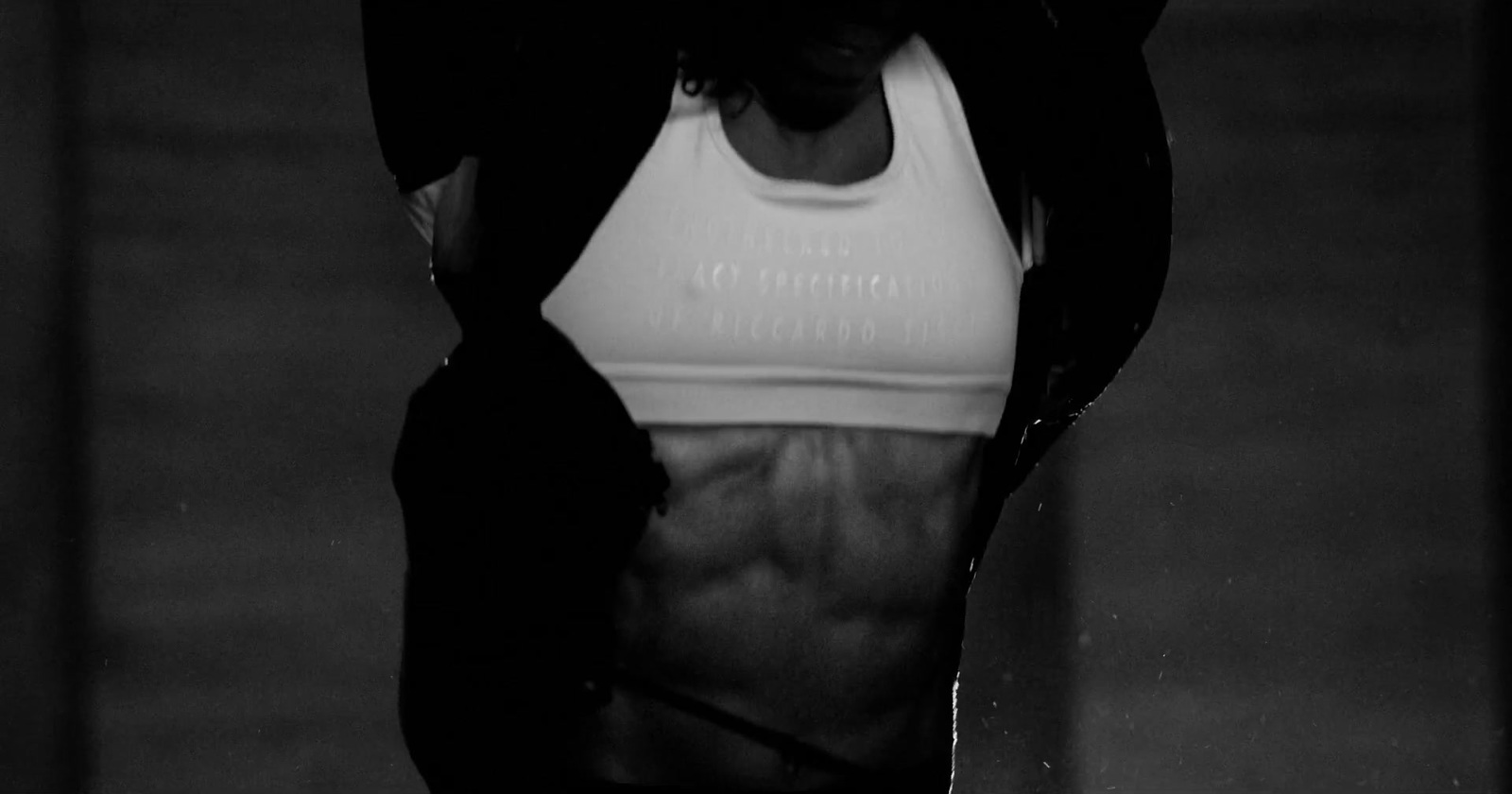 a black and white photo of a woman in a sports bra