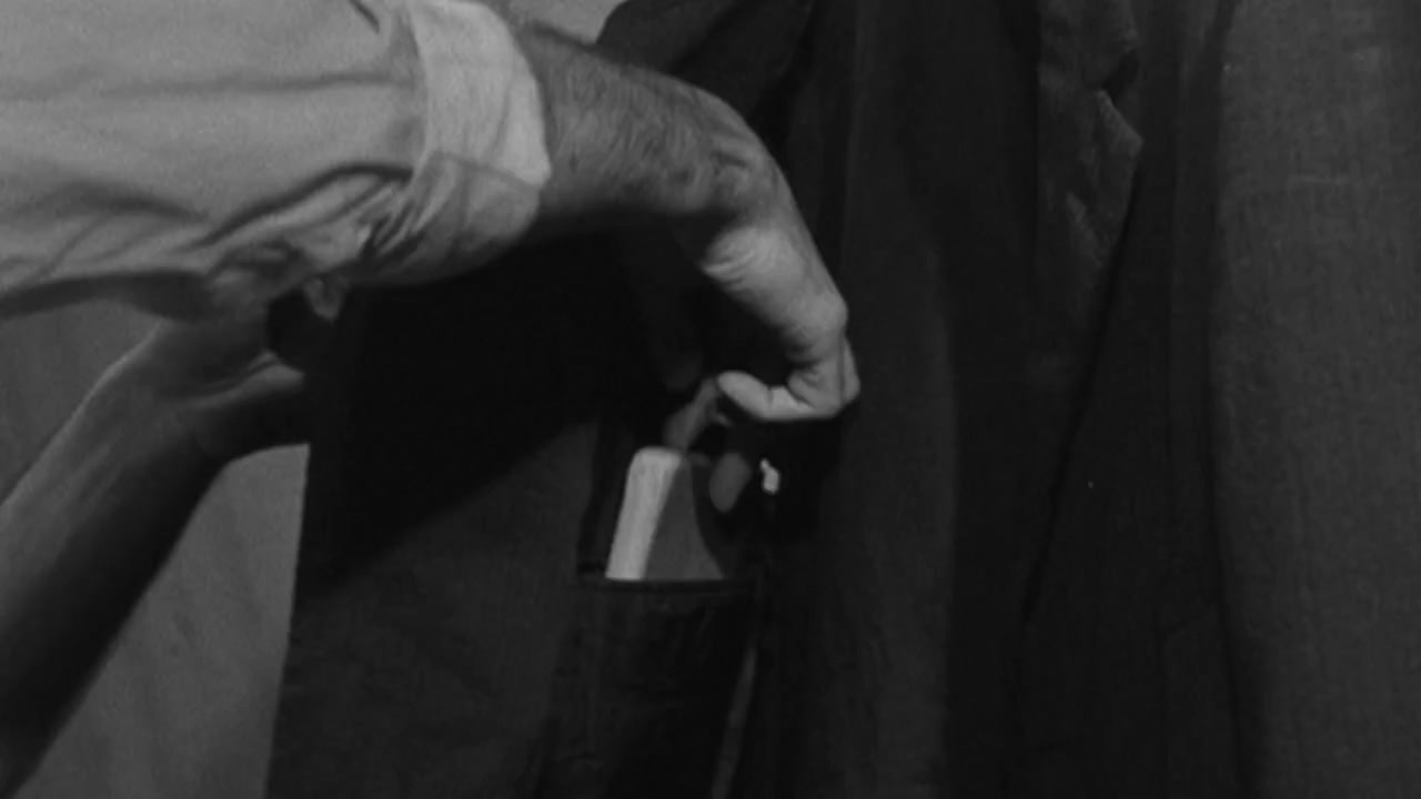 a black and white photo of a man holding a lighter