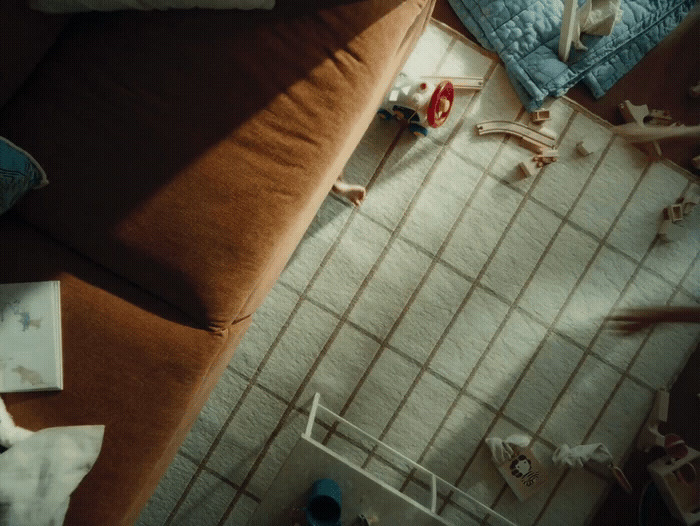 a living room with a brown couch and a white tiled floor